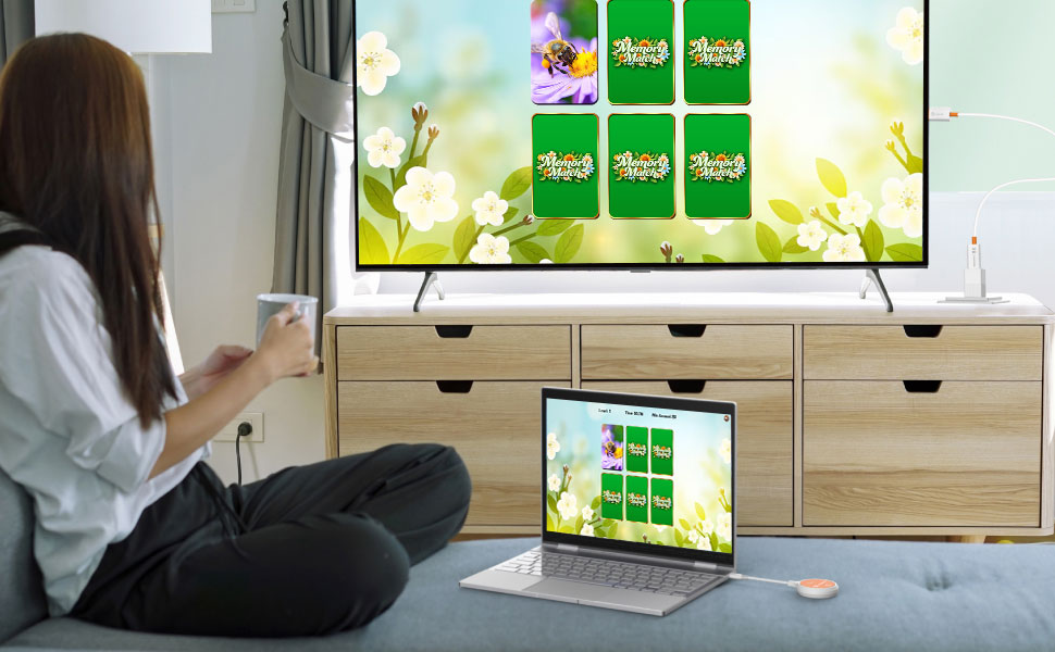 Staff member using laptop with j5create ScreenCast to display content on large casino-style TV